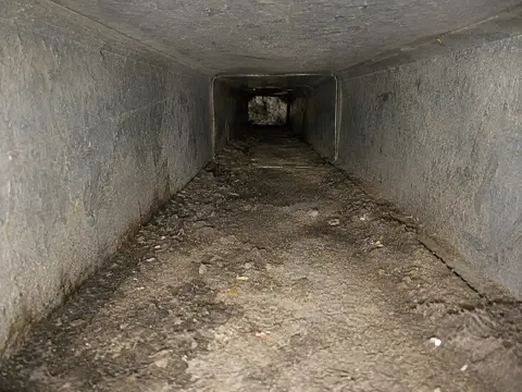 Dirty air duct filled with dust and debris before cleaning