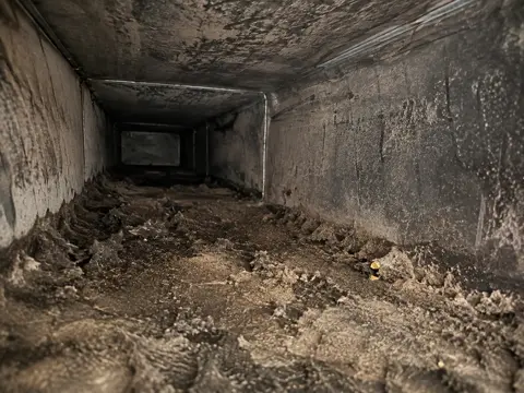 Heavily soiled air duct interior before professional cleaning